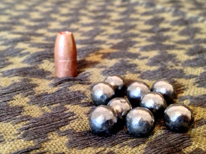 Buckshot Pellets next to 9mm Bullet